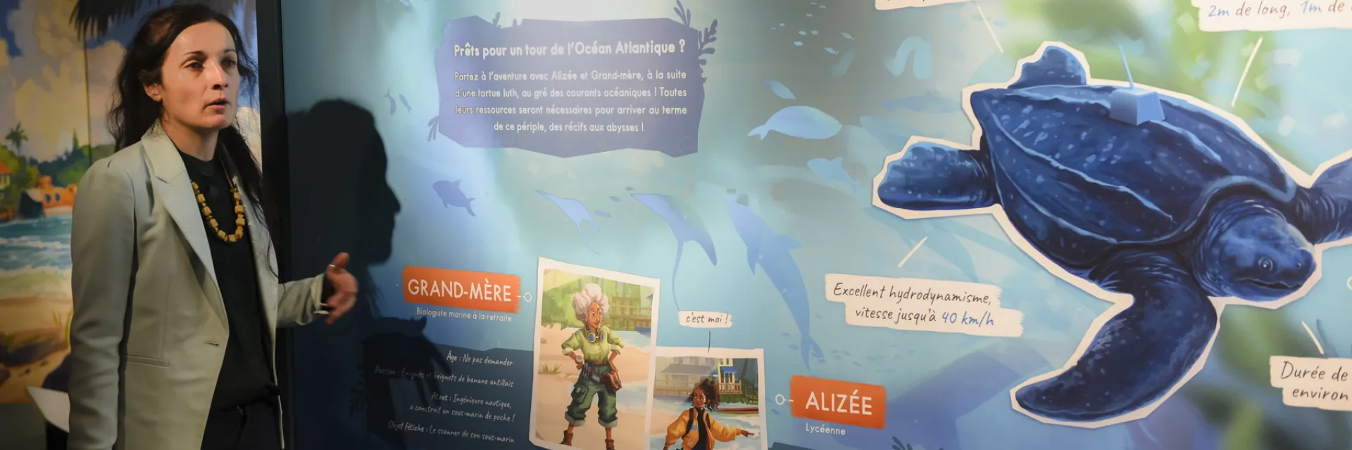 Laure Danilo (Directrice du MOBE) devant le cartel introductif de l'exposition 